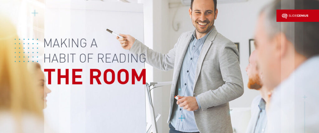 A man in a grey blazer and light blue shirt stands smiling while pointing at a flipchart. Text reads "Making a Habit of Reading the Room." Several people are seated around the man, listening attentively. A logo in the top right corner says "SlideGenius," suggesting tips for an effective pitch deck.