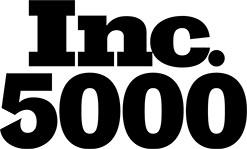 A black and white line drawing of a basket adorned with a large bow on top. The basket, perfect for presentations, contains an assortment of items, including a bottle, various boxes, and a bouquet of flowers.