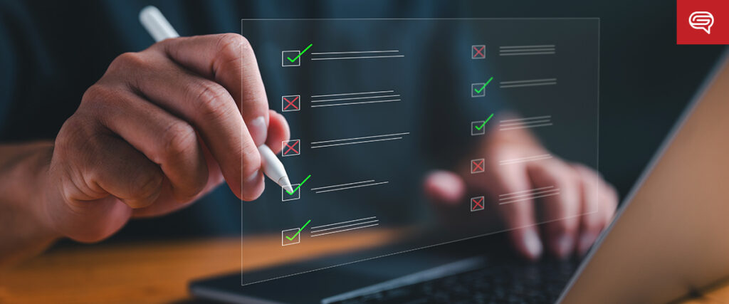 A hand holding a stylus is marking checkboxes on a floating, transparent checklist viewed in front of a laptop screen. Green check marks fill some boxes, while others have red X marks. The background is blurred, emphasizing the checklist and stylus, resembling elements from a pitch deck slide.