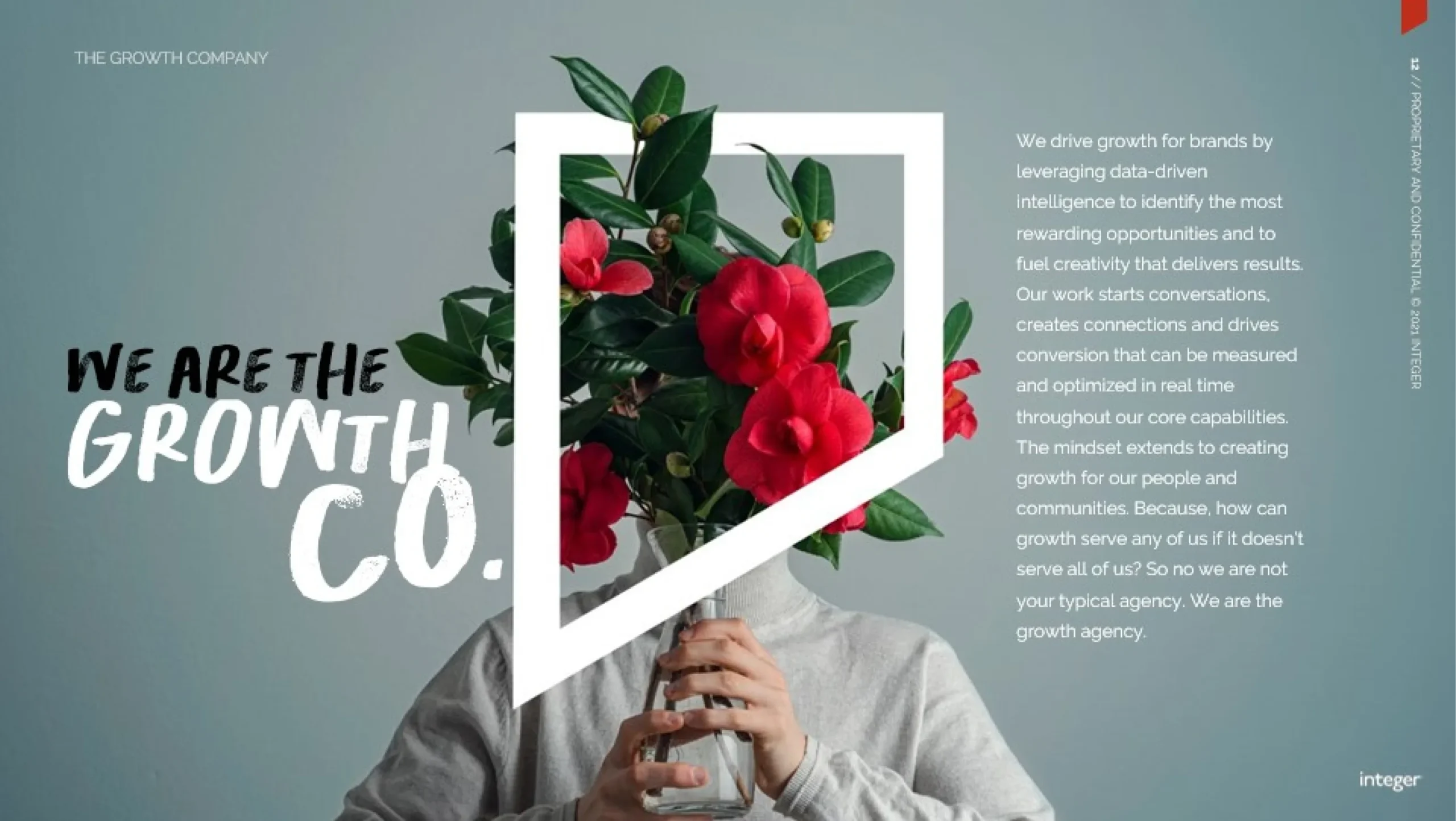A person in a gray turtleneck holds a clear vase with a flowering plant covering their face. The text overlay reads, 