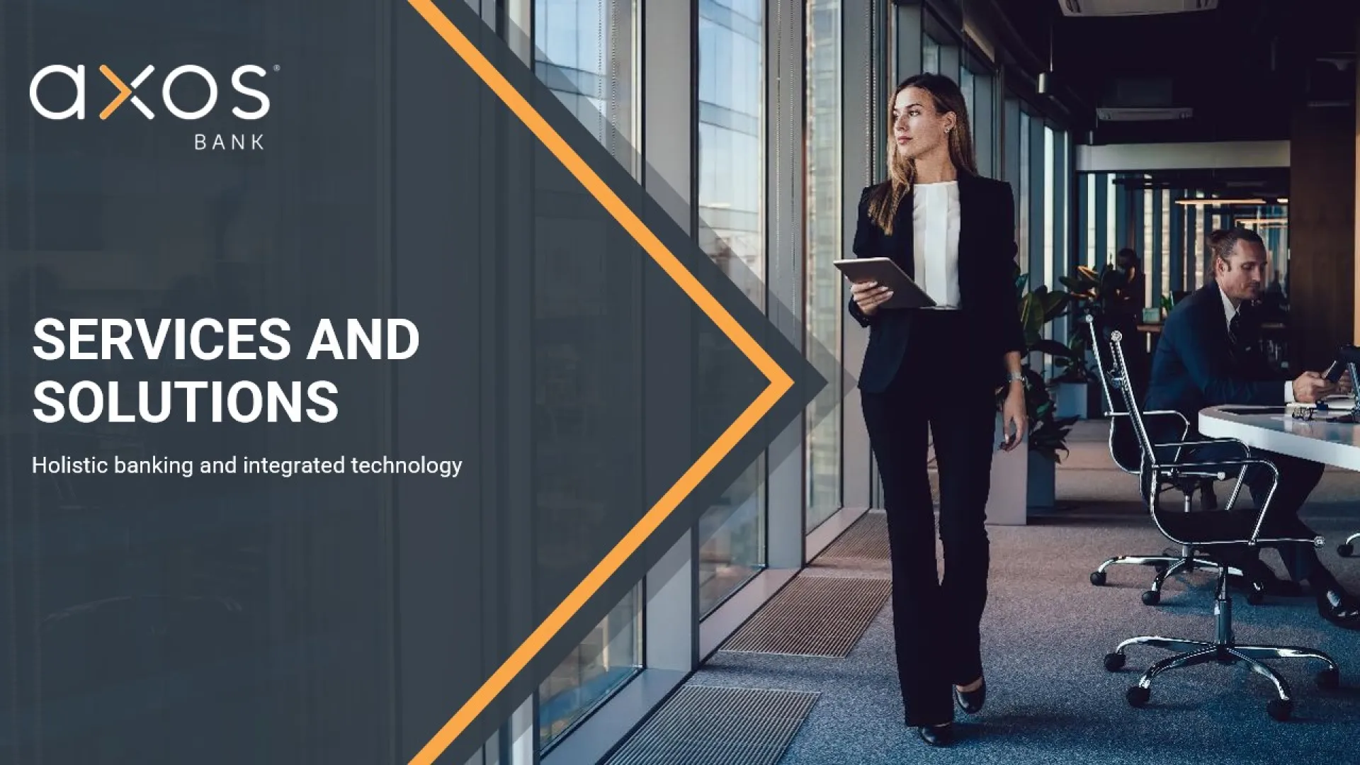 A businesswoman in a suit walks through a modern office corridor holding a tablet. The office has large windows, and another employee is working at a desk. The text reads: 