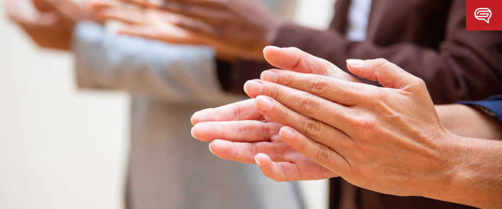 Close-up of diverse hands clapping, suggesting applause or appreciation. This gesture, often highlighted in case study slides, can influence decisions through powerful visual techniques. The background is softly blurred to maintain focus on the hands.